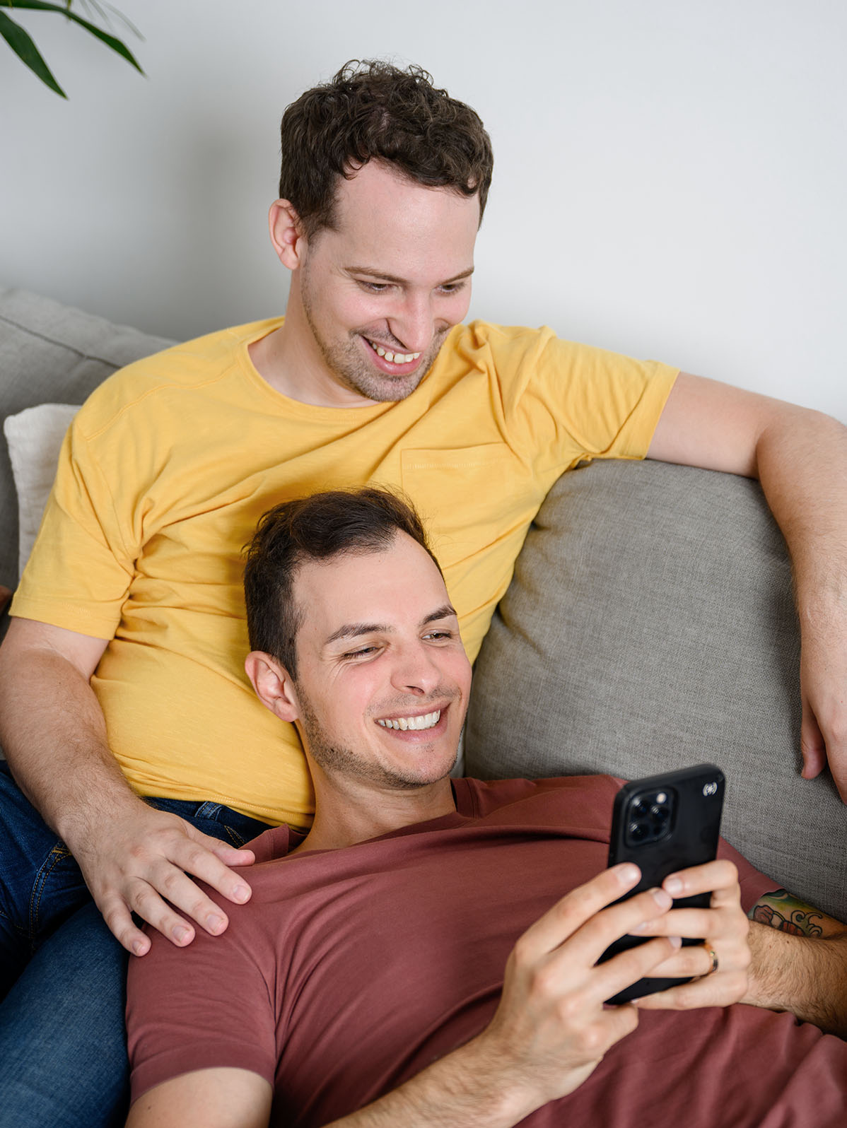 two-guys-on-couch-looking-at-mobile